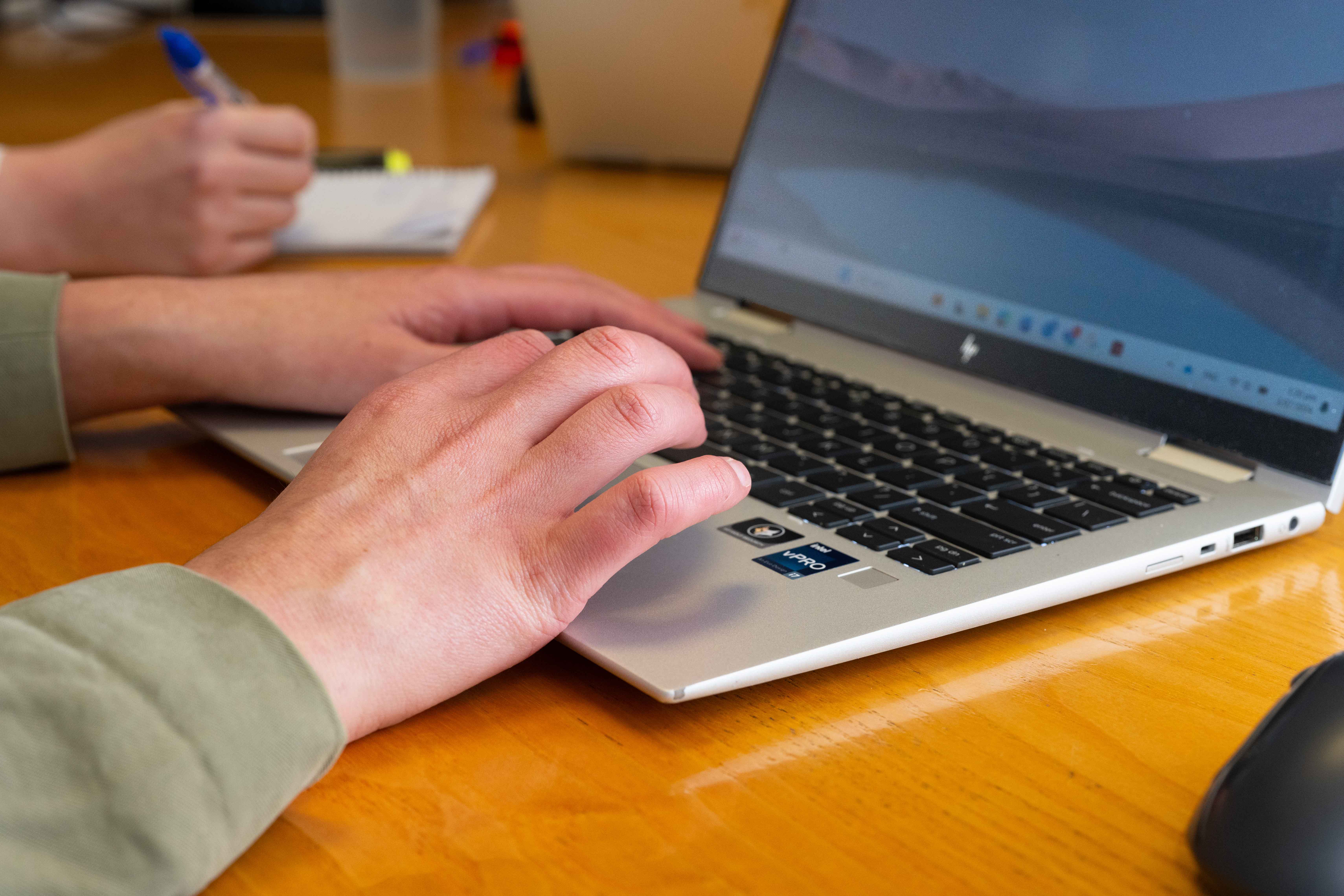 Hands typing on a laptop keyboard