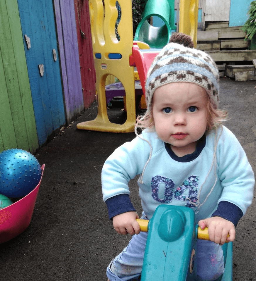 A small child riding a push along bike