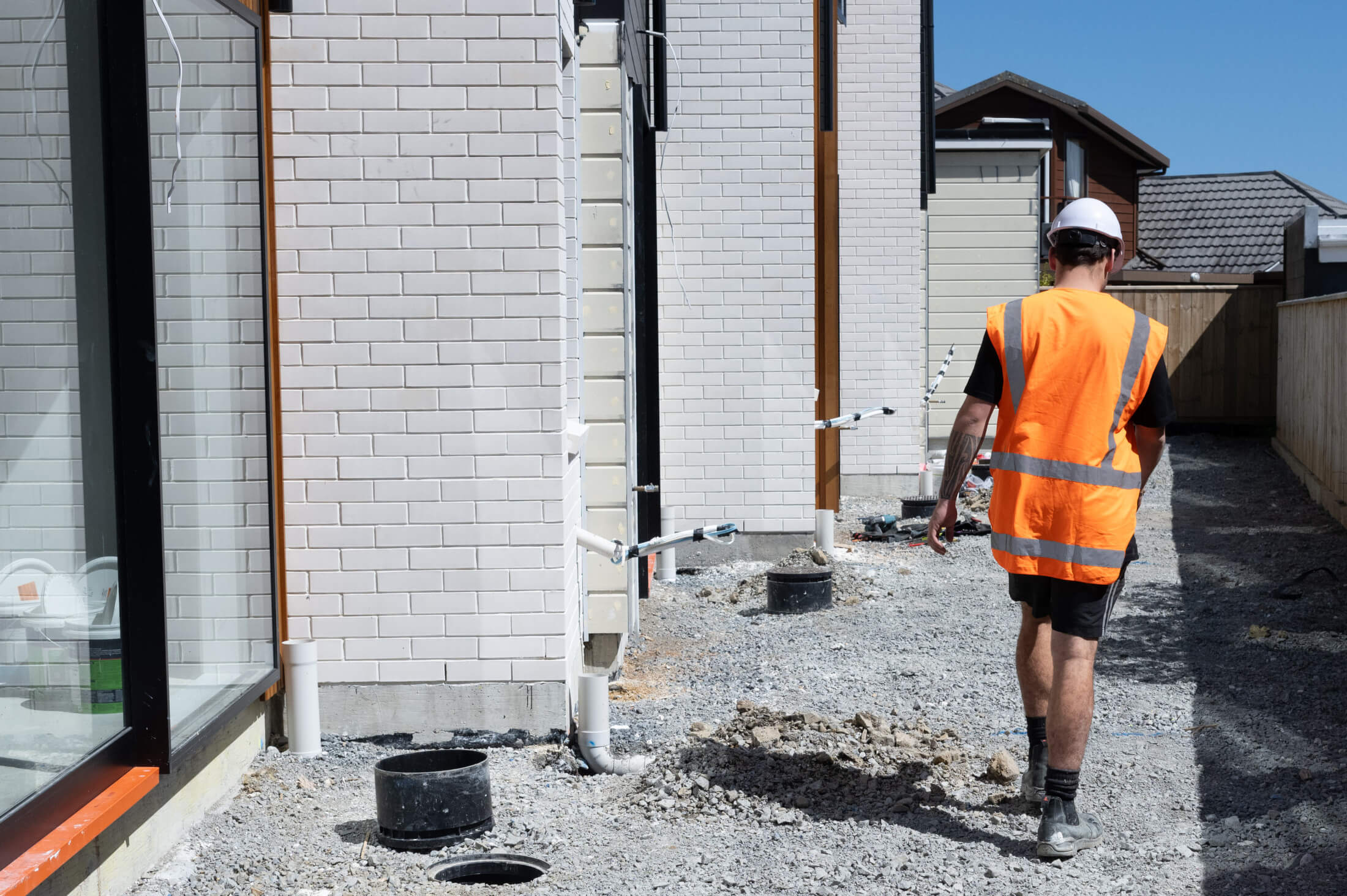 A tradie in a high-vis vest on a house building site