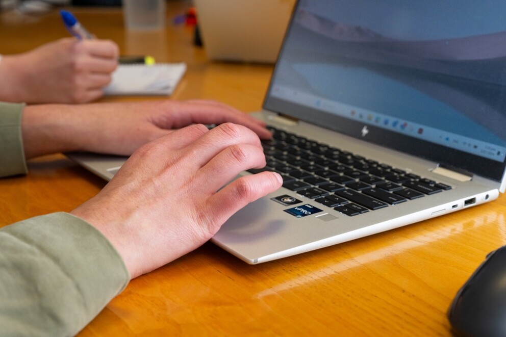 Close up of a person's hands typing on a laptop.